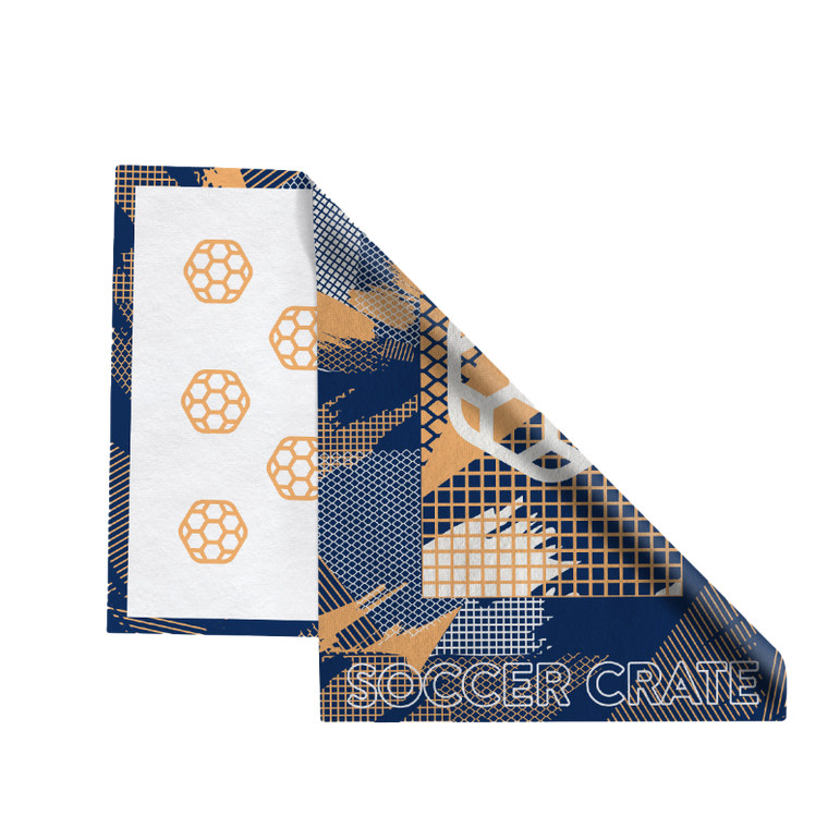 Folded navy and orange Juggler Towel with a white hexagon soccer ball and Soccer Crate lettering